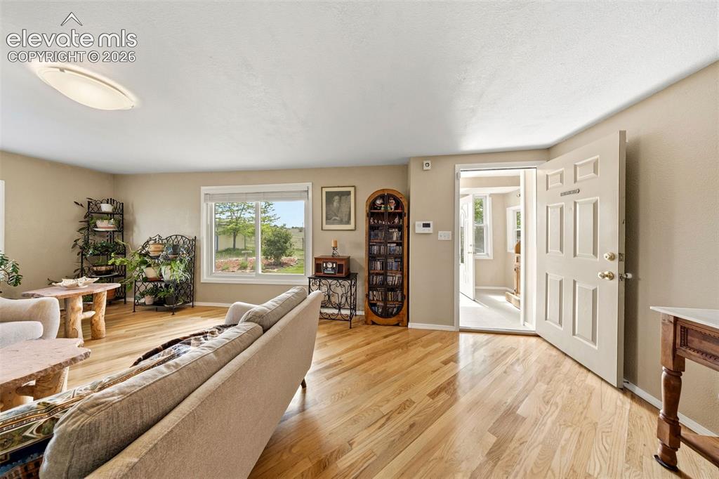 Image 5 of 40: Warm-toned wood-finish flooring throughout, complemented by a white ceiling
