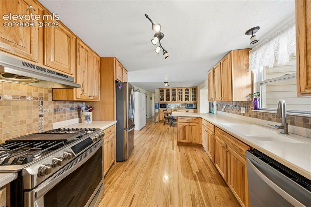 Image 7 of 40: Expansive kitchen featuring custom wood cabinets, flooring, light wood cabi