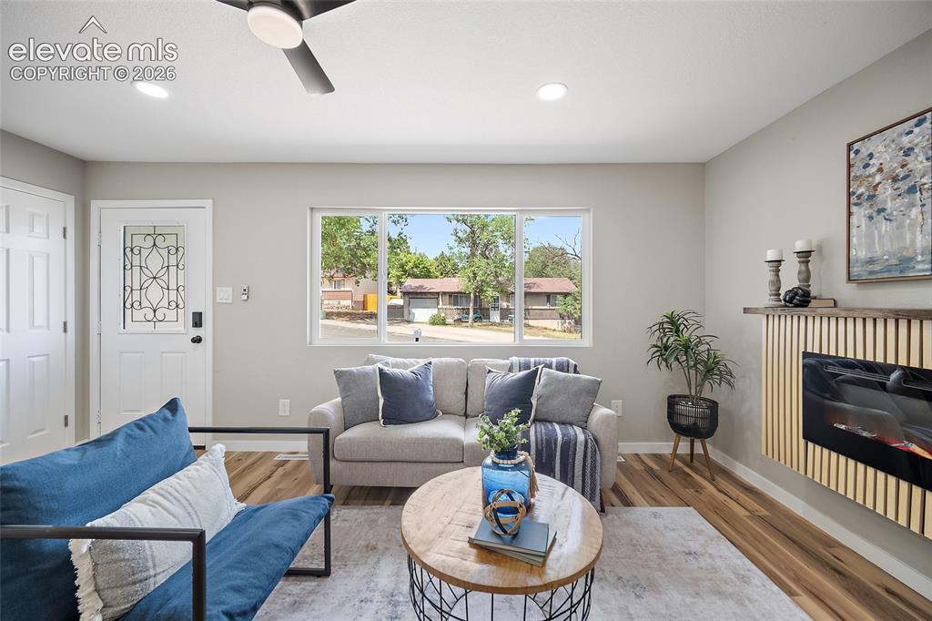 Image 12 of 49: Recessed lighting, wood-finish flooring, ceiling fan, decorative entry door