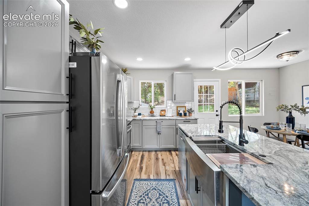 Image 19 of 49: Stainless steel appliances, grey cabinetry, light-toned wood-finish floorin
