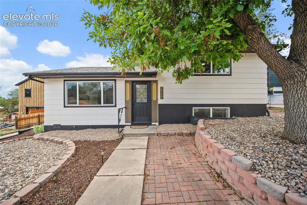 Image 3 of 49: Siding exterior with dark trim, dark entry door with decorative glass, conc