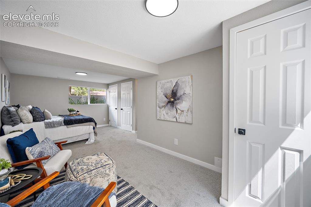 Image 35 of 49: Carpeted room with light gray walls, built-in ceiling lighting, and multipl
