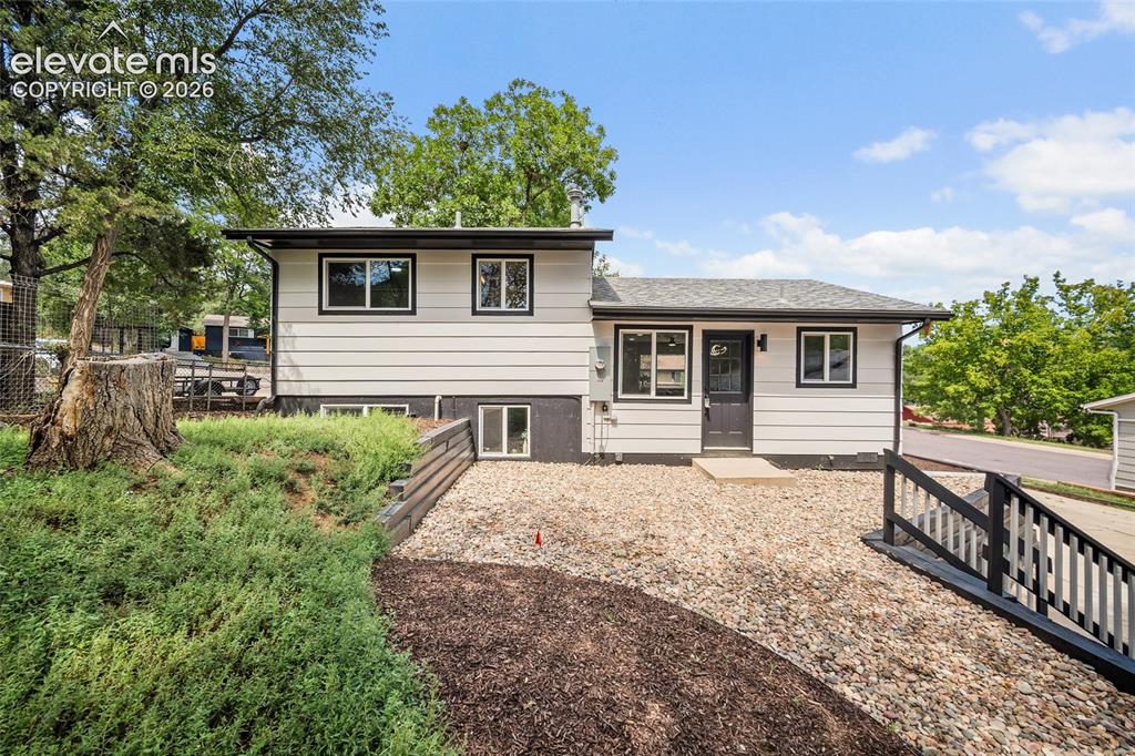 Image 41 of 49: Horizontal siding exterior with dark trim windows, dark entry door, and a g
