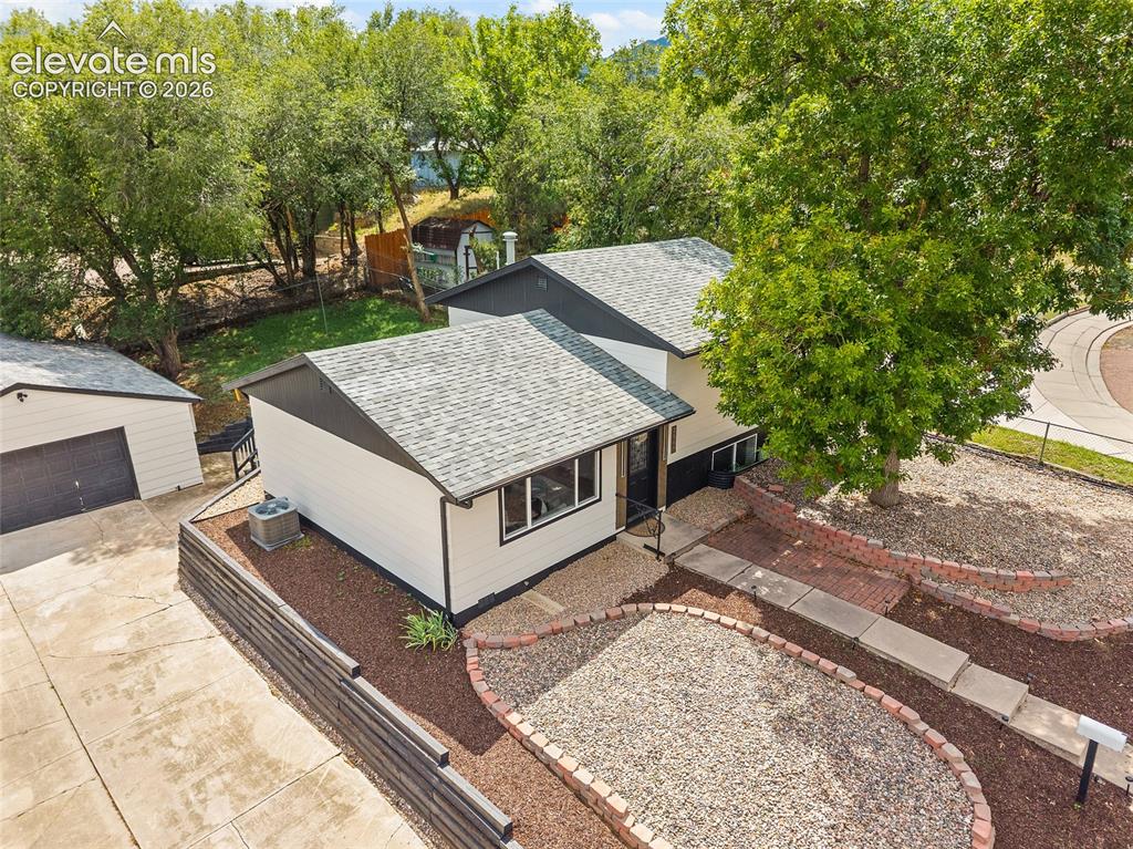 Image 42 of 49: Property exterior featuring a detached garage, a concrete driveway, a front