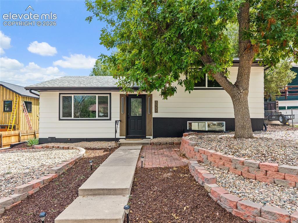 Image 43 of 49: Exterior featuring white siding with black trim, dark entry door, concrete 