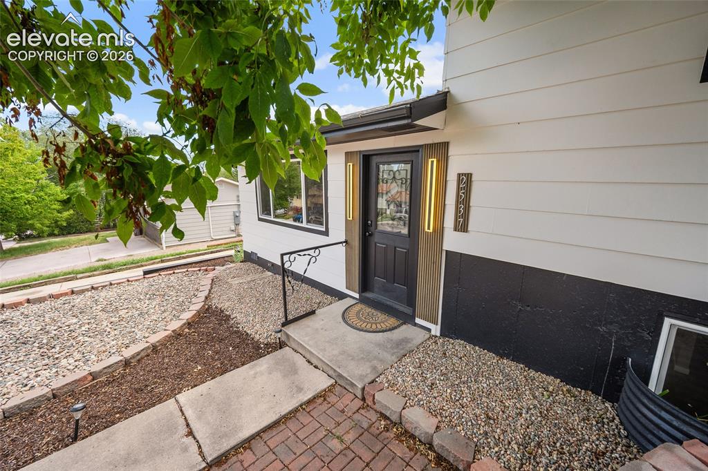 Image 6 of 49: Siding exterior with contrasting foundation, wood-look front door, and deco