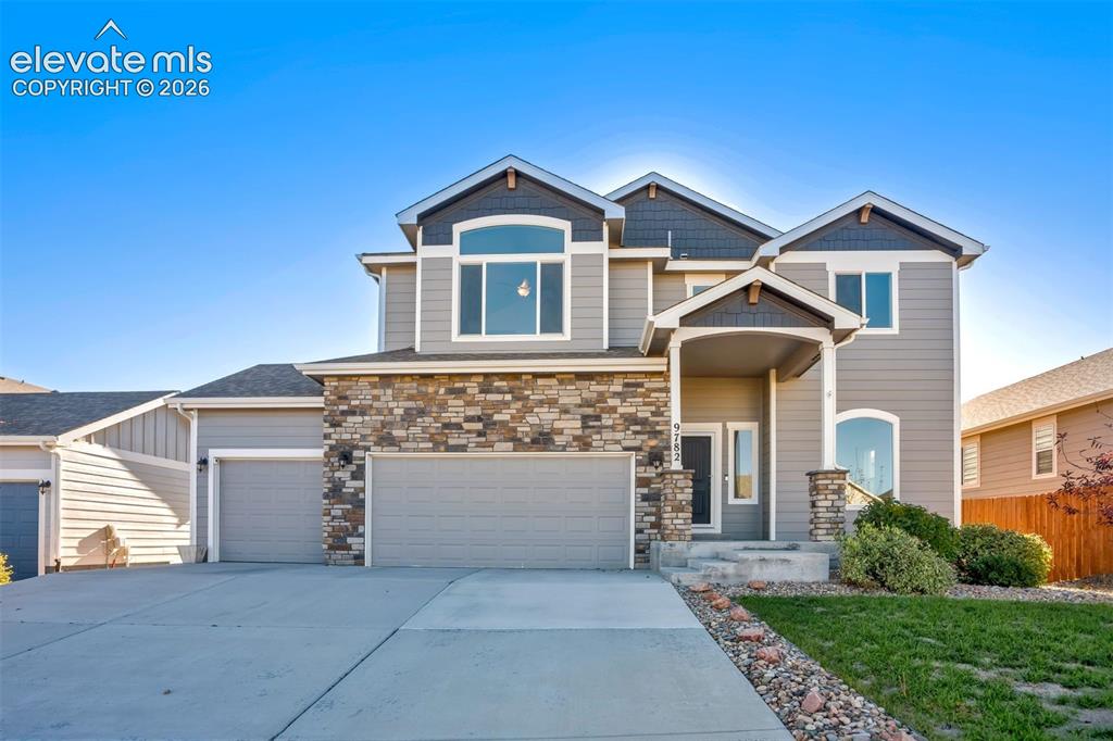 Image 1 of 47: Multi-level residence featuring a stone and siding exterior, an arched entr