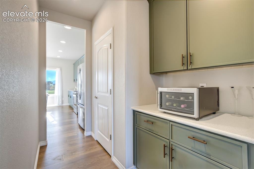 Image 11 of 47: Built-in cabinetry with sage green finish and bronze hardware