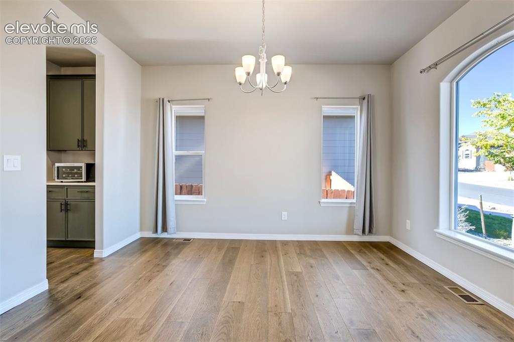 Image 13 of 47: Wood-finish flooring throughout, complemented by a prominent arched window