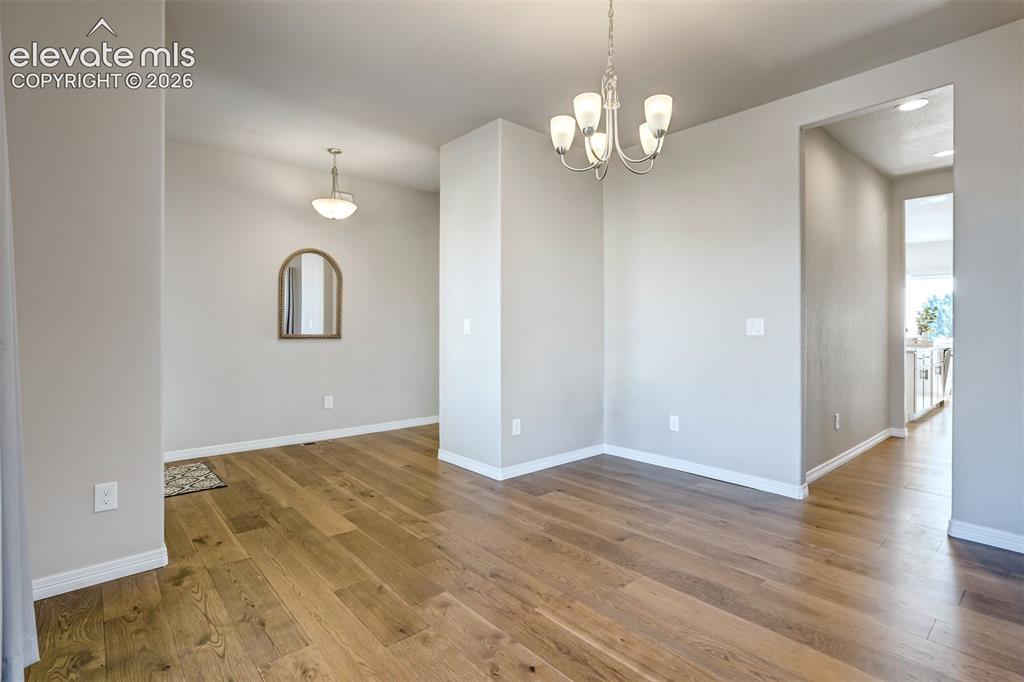 Image 14 of 47: Wood-finish flooring, recessed lighting, and a modern chandelier