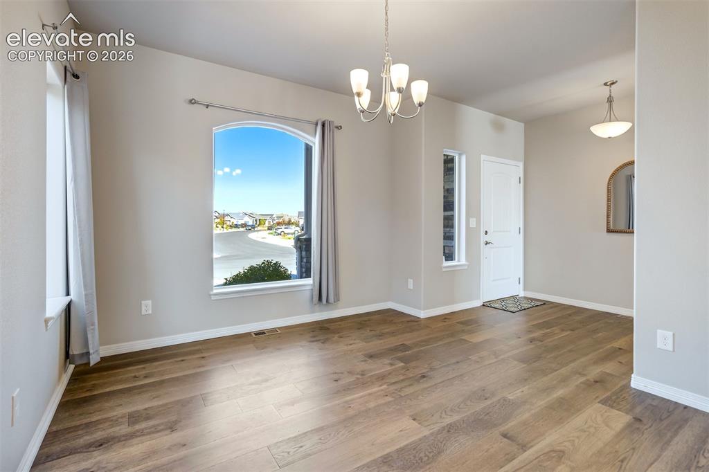 Image 15 of 47: Arched window, wood-finish flooring, white trim, recessed lighting, and a c