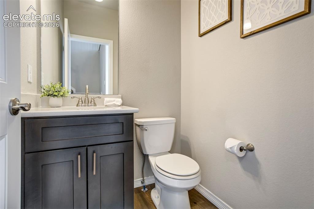 Image 16 of 47: Dark wood-finish vanity with a light-colored countertop and brushed nickel 