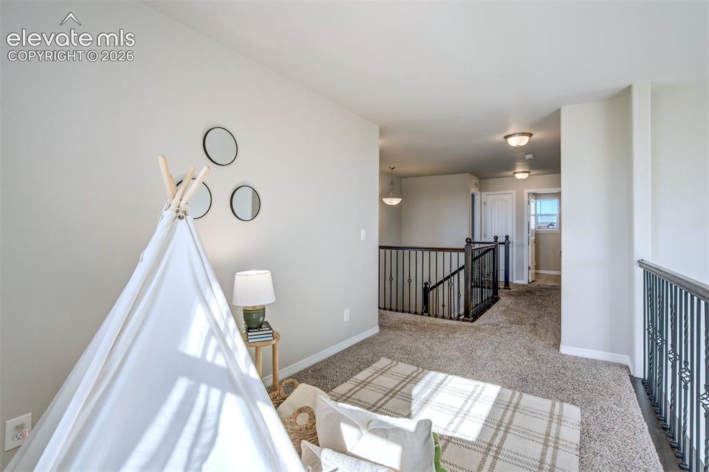 Image 19 of 47: Carpeted loft area with wrought iron railings and recessed lighting