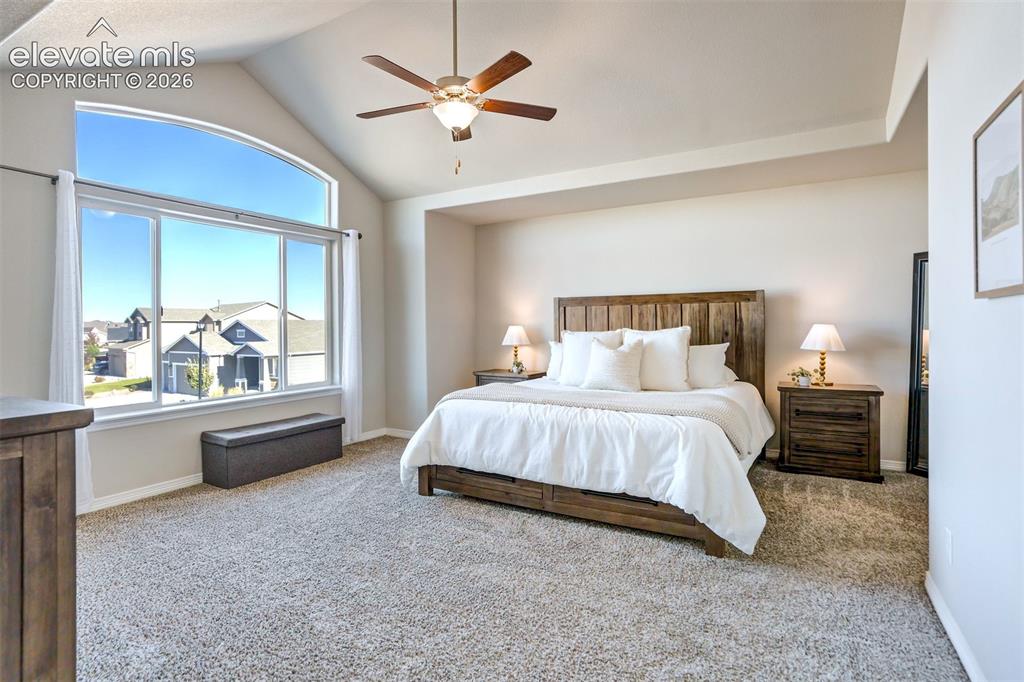 Image 20 of 47: Vaulted ceiling with a ceiling fan, arched window, and plush carpeting