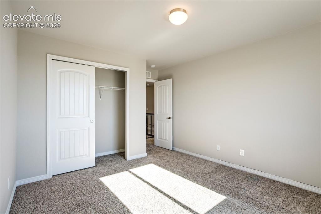 Image 28 of 47: Light gray painted walls with textured carpeting, white sliding closet door