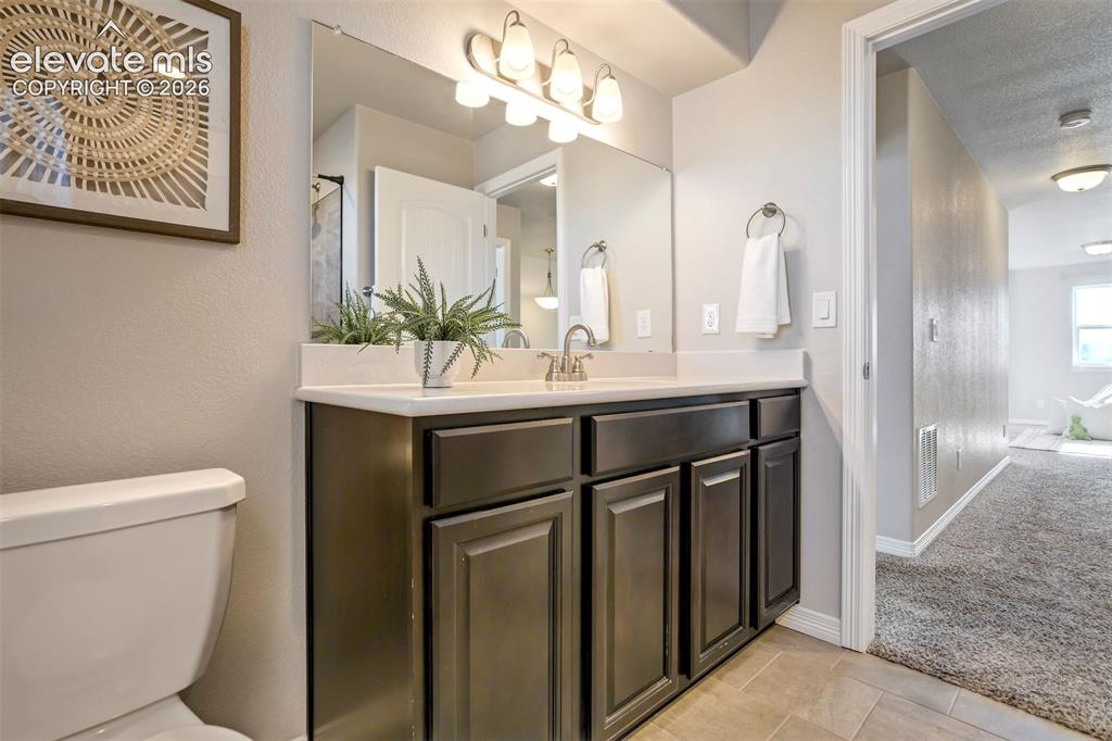 Image 32 of 47: Vanity with an integrated sink, brushed nickel faucet, and a wall-mounted m