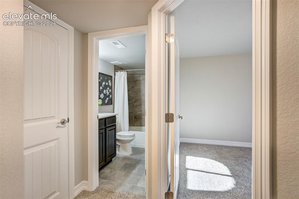 Image 36 of 47: Bathroom with dark wood-finish vanity and tiled shower surround