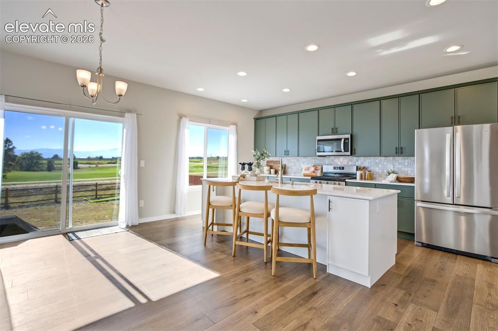 Image 4 of 47: Open-concept kitchen and dining area featuring wood-finish flooring, a kitc