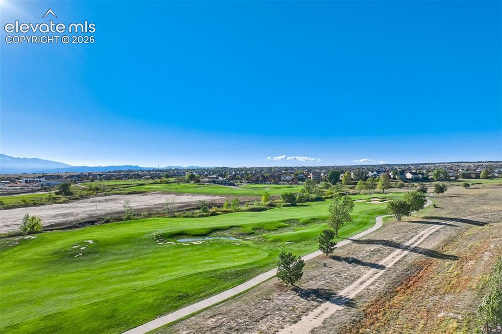 Image 46 of 47: Expansive golf course setting featuring manicured greens and a paved cart p