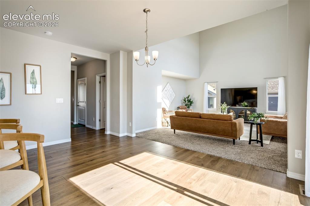 Image 8 of 47: Open concept living space featuring wood-finish flooring, vaulted ceilings,