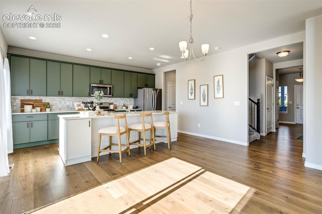 Image 9 of 47: Expansive kitchen island with white countertop, recessed lighting, wood-fin