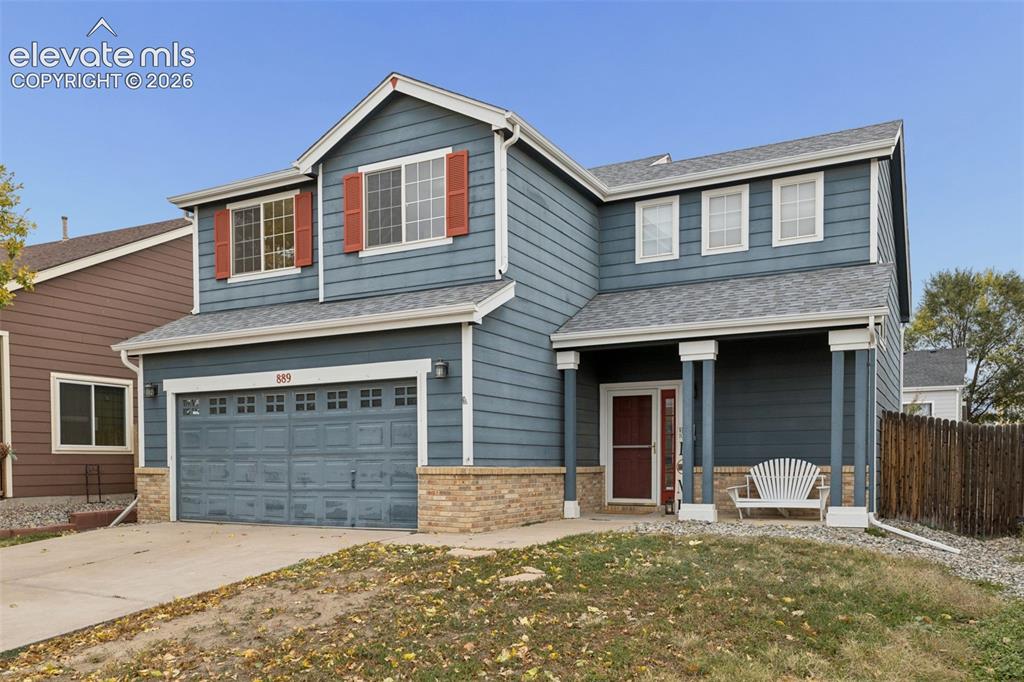 Caption: Two-story residence featuring horizontal lap siding, stone veneer accents, an attached two-car garag