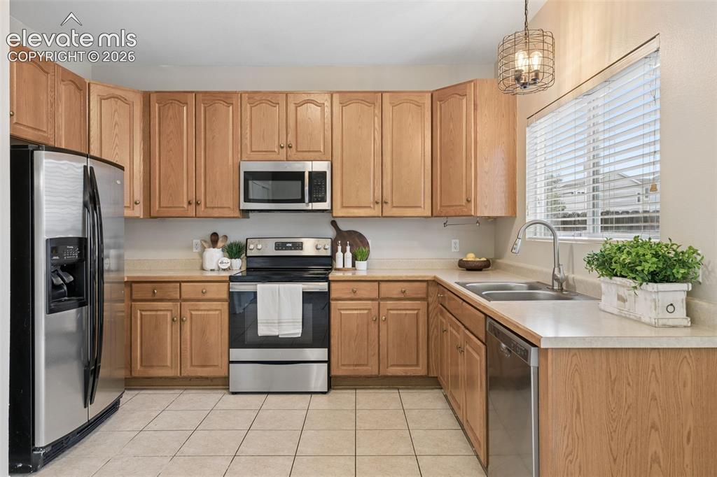 Image 11 of 26: Kitchen featuring light wood cabinetry, stainless steel appliances, neutral