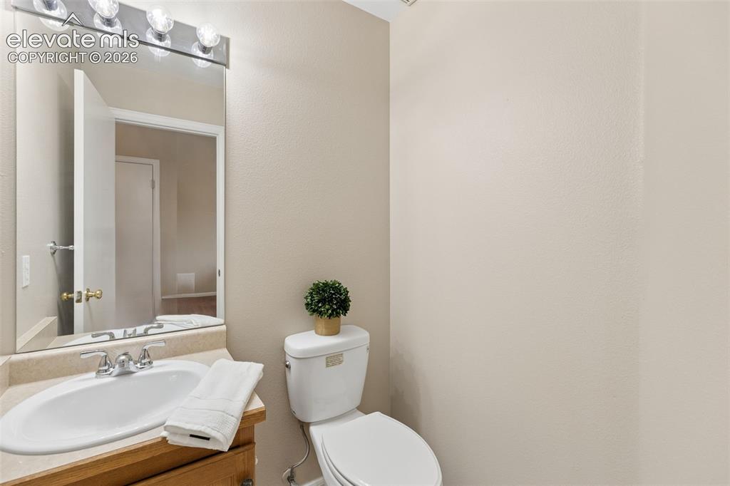 Image 13 of 26: Built-in vanity with a stone-finish countertop, undermount oval sink, polis