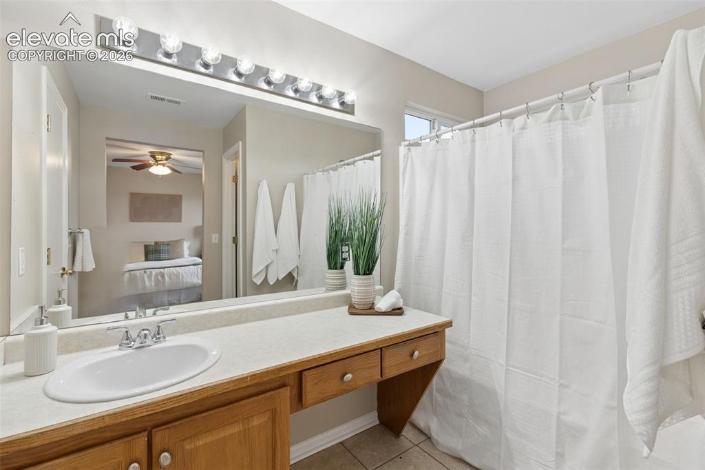 Image 18 of 26: Vanity featuring a light-toned countertop, integrated oval sink, and wood c