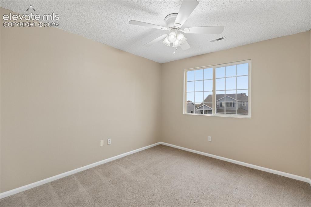 Image 19 of 26: Neutral-toned interior space featuring wall-to-wall carpeting, a textured c