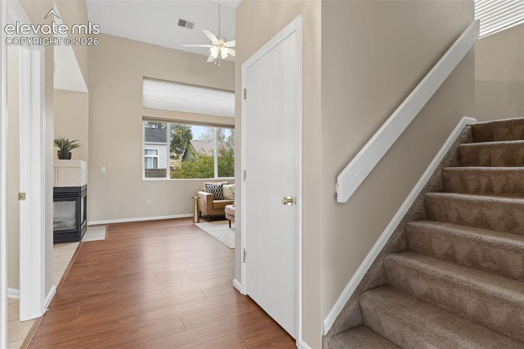 Image 2 of 26: High-ceiling interior featuring wood-finish flooring, a built-in fireplace 