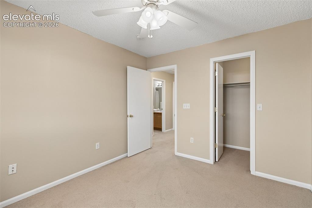 Image 20 of 26: Neutral-toned room featuring carpeted flooring, a ceiling fan with integrat