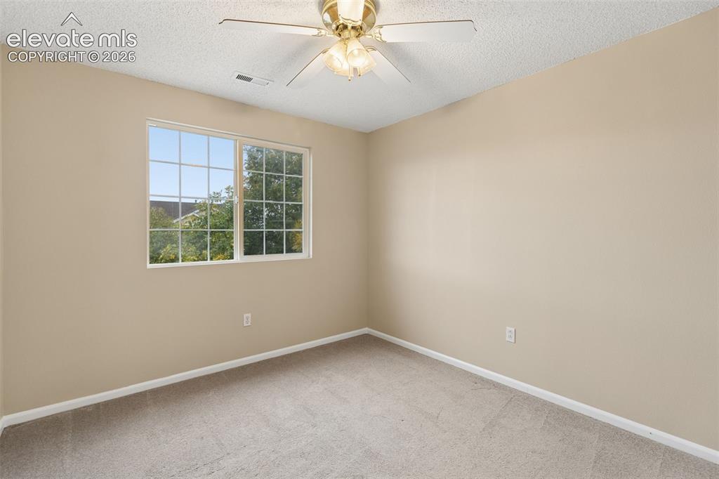 Image 21 of 26: Neutral-toned interior space featuring wall-to-wall carpeting, a multi-pane