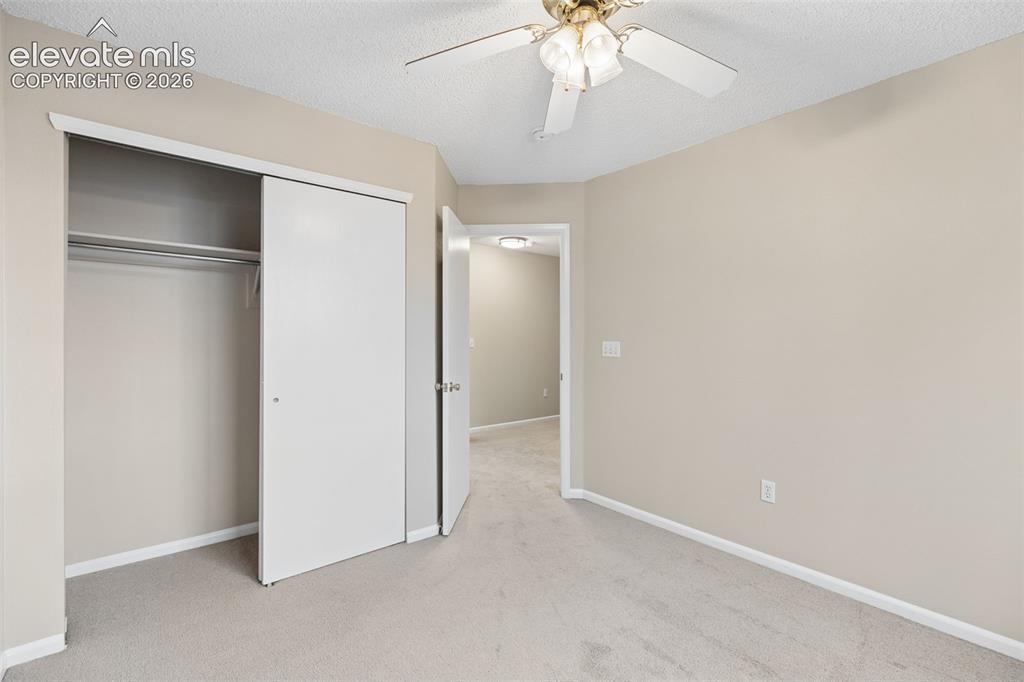 Image 22 of 26: Neutral-toned interior featuring wall-to-wall carpeting, a sliding-door clo