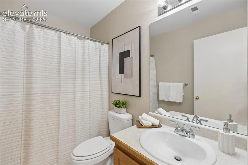 Image 23 of 26: Bathroom featuring a vanity with a drop-in sink, chrome fixtures, a large w
