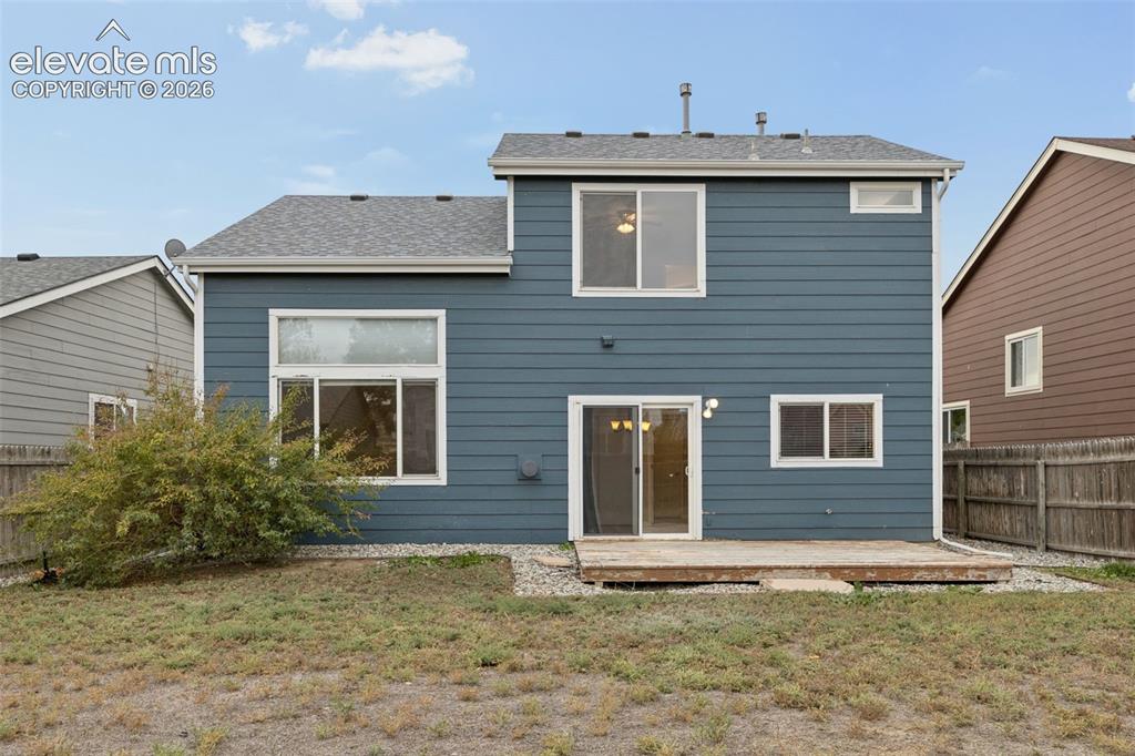 Image 25 of 26: Two-story exterior featuring blue horizontal lap siding, a rear wood deck, 