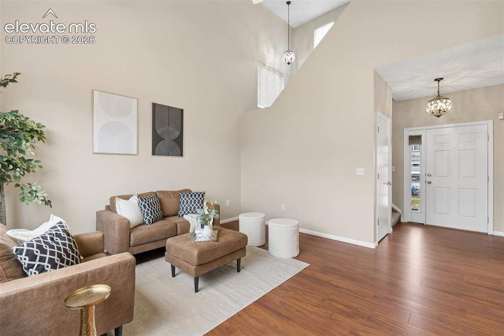 Image 3 of 26: High-ceilinged interior featuring wood-finish flooring, a paneled front doo