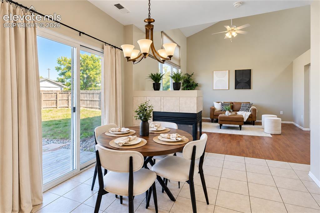 Image 9 of 26: Vaulted ceilings, tiled dual-sided fireplace, sliding glass door to exterio