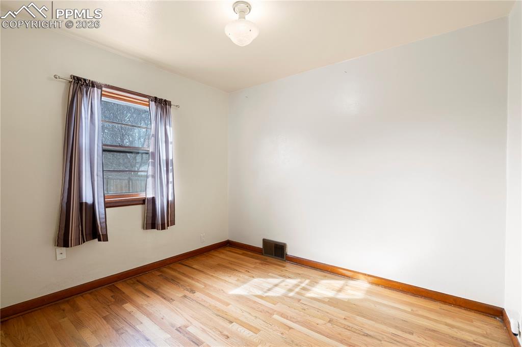 Image 10 of 21: Spare room featuring light wood finished floors and baseboards