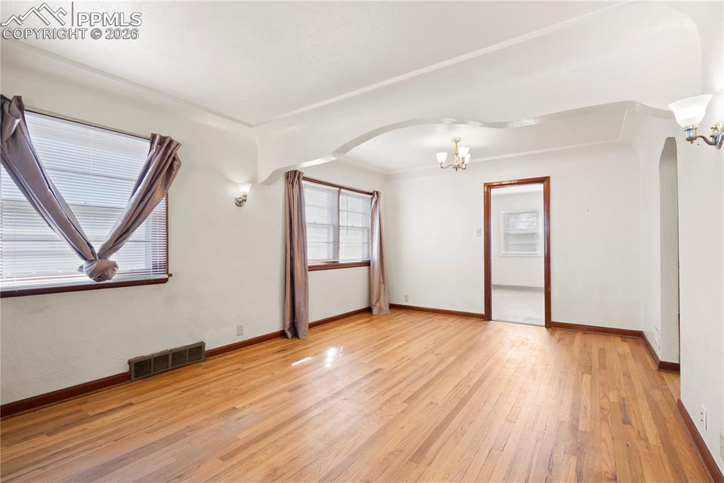 Image 17 of 21: Additional living space with light wood-style floors, a chandelier, and arc