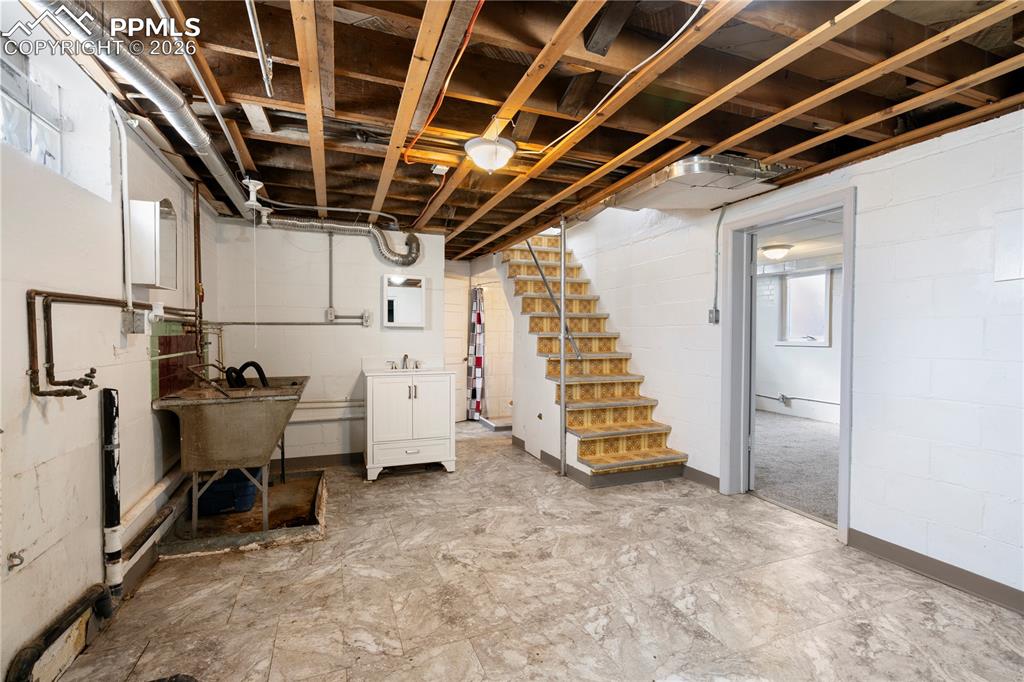 Image 4 of 21: Unfinished below grade area featuring stairway