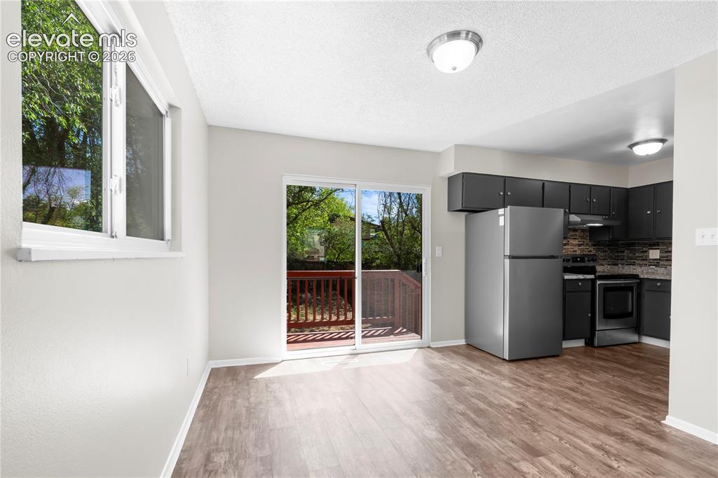 Image 10 of 32: Open-concept living space featuring wood-finish flooring and neutral wall t