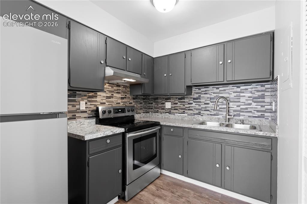 Image 12 of 32: Updated kitchen featuring gray cabinetry, stainless steel appliances, a mos