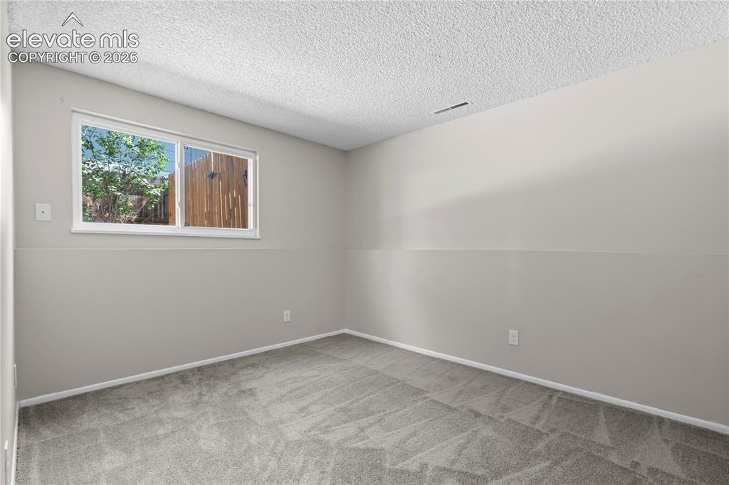 Image 19 of 32: Carpeted room with a white-framed window