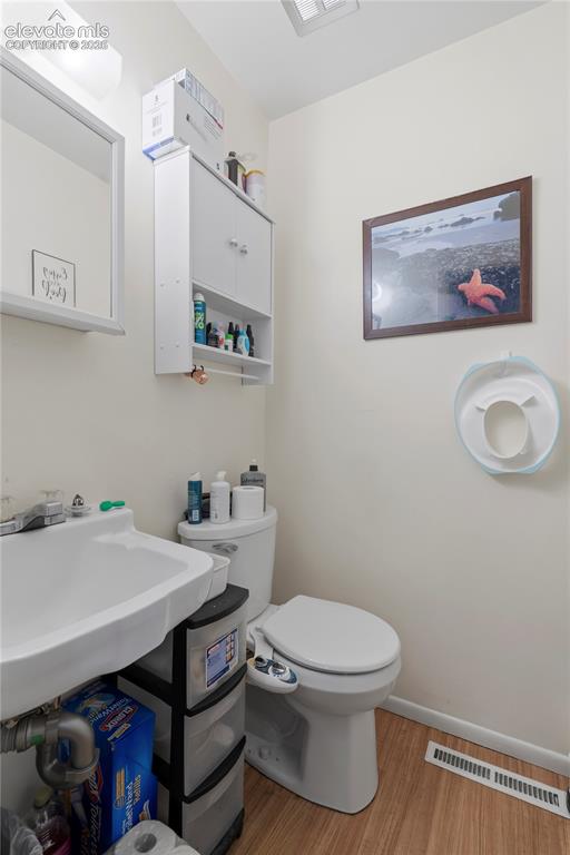 Image 26 of 32: Compact bathroom featuring a wall-mounted sink, a toilet with an attached b