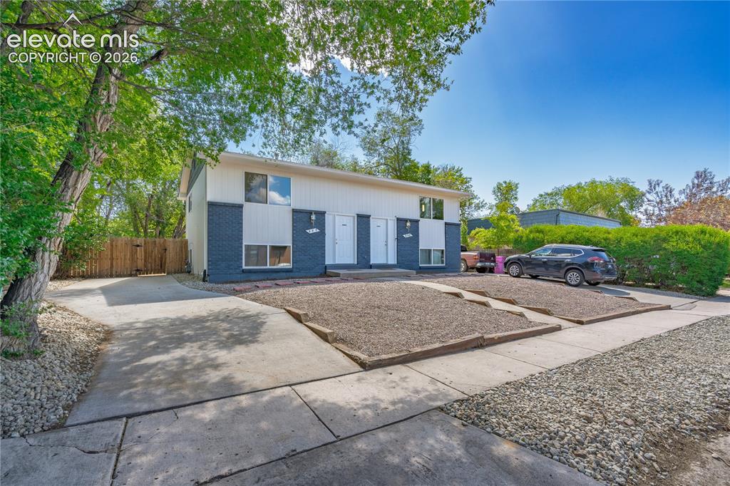 Image 3 of 32: Two-story property featuring a white and dark blue exterior, multiple entry