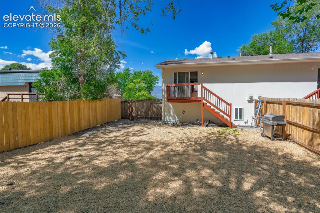 Image 32 of 32: Expansive backyard featuring a gravel surface, wood privacy fencing, and ma