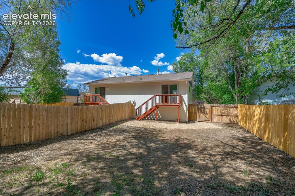 Image 4 of 32: Expansive backyard featuring a new wood privacy fence, a gravel patio area,