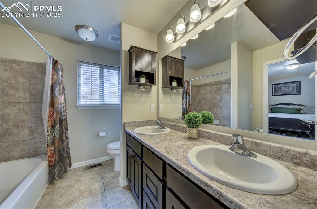 Image 16 of 34: Bathroom featuring tile patterned floors, double vanity, and shower / bath 