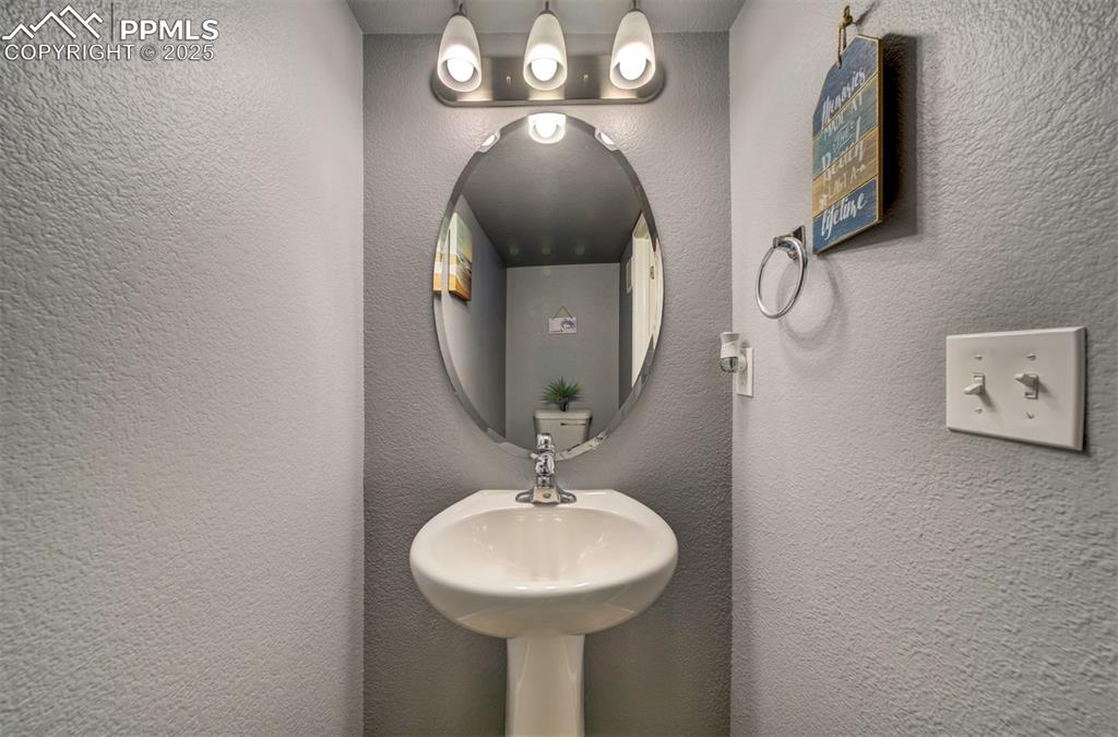 Image 27 of 34: Half bathroom in basement featuring tile patterned floors & single vanity 